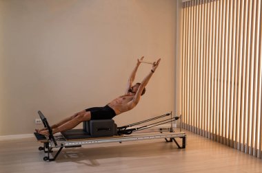 Reformcu üzerinde pilates yapan bir adam.