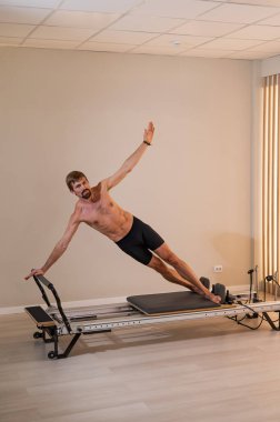 Reformcu üzerinde pilates yapan bir adam.