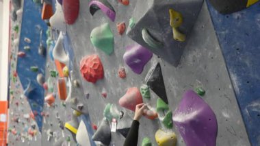 Beyaz adam tırmanma duvarında eğitim görüyor.
