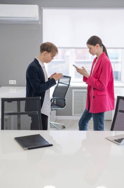 Meslektaşlar iş yerinde akıllı telefon kullanırlar.