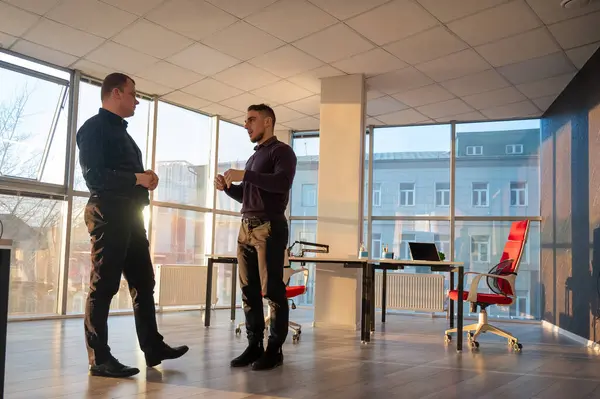 Ofiste konuşan iki beyaz adam.