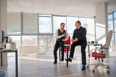 İş arkadaşları ofiste kahve içiyor.