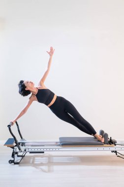 Asyalı kadın reformcuda pilates yapıyor.
