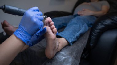 Güzellik salonunda hırdavat pedikür yapan hamile bir kadın.