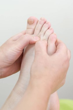 Bir kadının ayağına masaj yapılıyor.