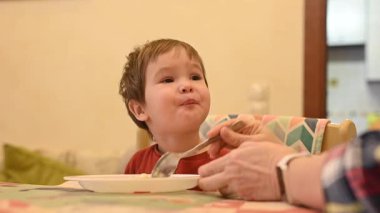 Büyükannem torununu kaşıkla besler.