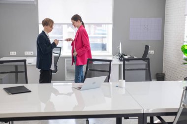 Meslektaşlar iş yerinde akıllı telefon kullanırlar.