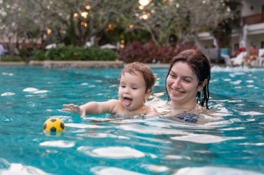 Beyaz kadın tatilde havuzda yüzerken oğlunu kucağına aldı