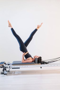 Asyalı kadın reformcuda pilates yapıyor.