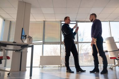 Ofiste konuşan iki beyaz adam.