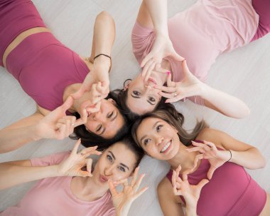 İki Kafkasyalı ve iki Asyalı kadın spor giyim kuşamında uzanır.