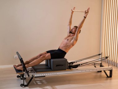 Reformcu üzerinde pilates yapan bir adam.