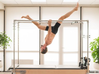 Bir adam yenilikçi bir makine üzerinde hava tatbikatları yapıyor.