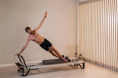 Reformcu üzerinde pilates yapan bir adam.