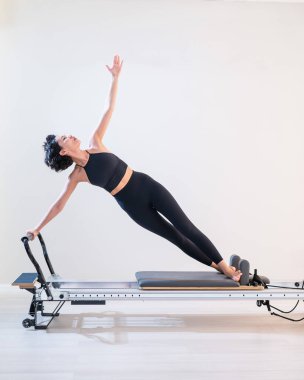 Asyalı kadın reformcuda pilates yapıyor.
