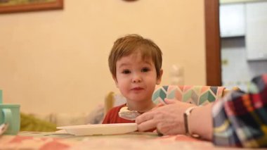 Büyükannem torununu kaşıkla besler.