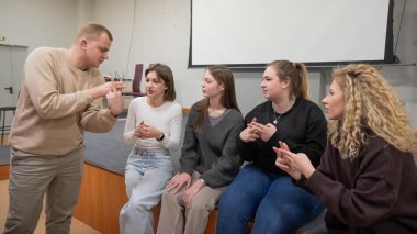 Gençler üniversite sınıfında işaret diliyle iletişim kurarlar.