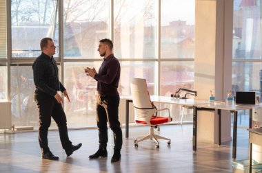 Ofiste konuşan iki beyaz adam.