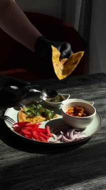 Siyah eldiven giyen bir şef fajita hazırlar.