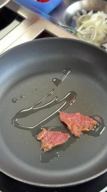 Şef kızartma tavasında dana eti kızartıyor.