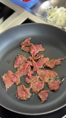 Şef kızartma tavasında dana eti kızartıyor.