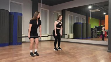 Kafkasyalı kadın kişisel eğitim sırasında halterci Romanyalı kaldırma yapıyor