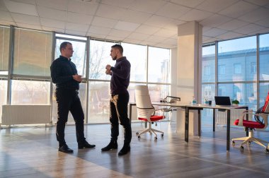 Ofiste konuşan iki beyaz adam.