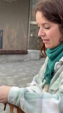 Beyaz kadın Jack Russell Terrier 'ını gezdirirken akıllı telefon kullanıyor.