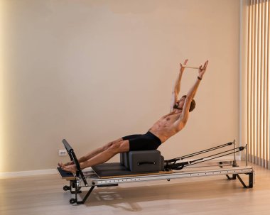 Reformcu üzerinde pilates yapan bir adam.