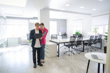 Meslektaşlar belgeli bir klasöre bakar ve iş konularını tartışırlar