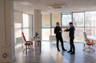 Ofiste konuşan iki beyaz adam.