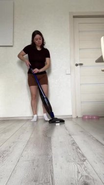 Beyaz kadın yerleri süpürüyor.