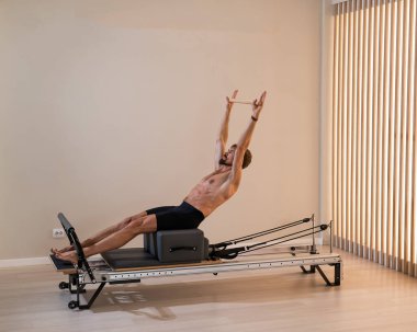 Reformcu üzerinde pilates yapan bir adam.