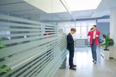 Meslektaşlar iş aralarında akıllı telefon kullanırlar