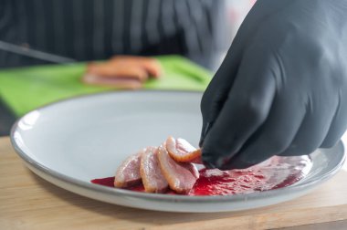 Şef ördeği kızılcık sosuna koyar.