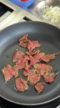 Şef kızartma tavasında dana eti kızartıyor.