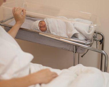 Genç bir anne, doğumevindeki yeni doğan oğluna hayran.