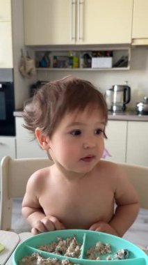 Babam bir yaşındaki çocuğunu kaşıkla yulaf lapasıyla besliyor.