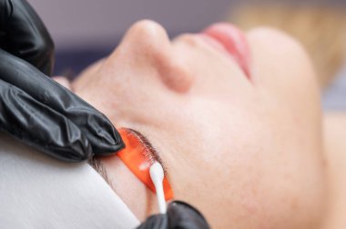 Beyaz kadın kirpik temizleme prosedüründen geçiyor.