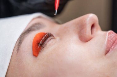 Beyaz kadın kirpik temizleme prosedüründen geçiyor.