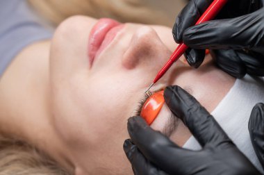 Beyaz kadın kirpik temizleme prosedüründen geçiyor.