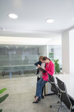 Meslektaşlar belgeli bir klasöre bakar ve iş konularını tartışırlar