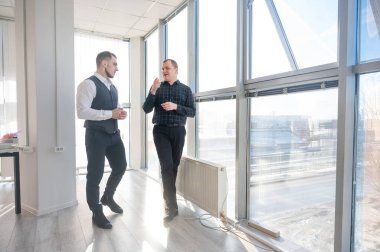 Ofiste konuşan iki beyaz adam.