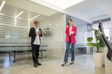 Meslektaşlar iş aralarında akıllı telefon kullanırlar