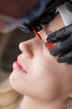 Beyaz kadın kirpik temizleme prosedüründen geçiyor.