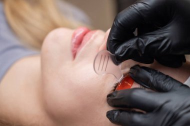 Beyaz kadın kirpik temizleme prosedüründen geçiyor.