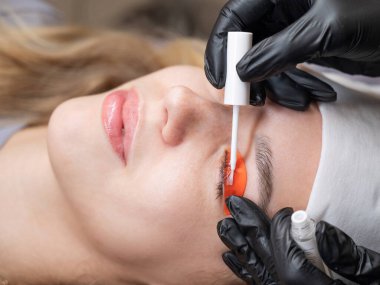 Beyaz kadın kirpik temizleme prosedüründen geçiyor.