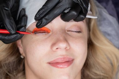 Beyaz kadın kirpik temizleme prosedüründen geçiyor.