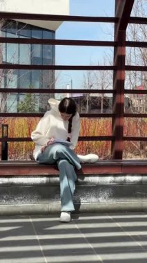 Açık havada kalemle çizim yapan beyaz bir kadın.