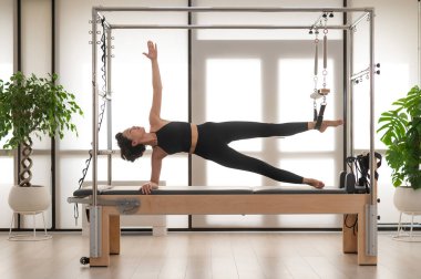 Asyalı kadın reformcuda pilates yapıyor.